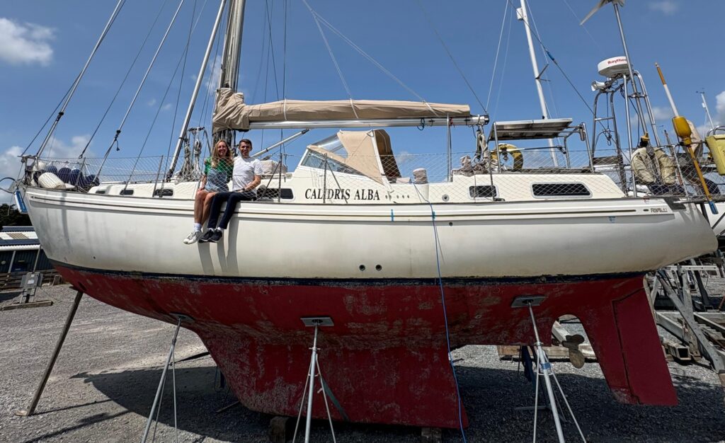 Fran and Jack sitting on Calidris Alba in the boatyard